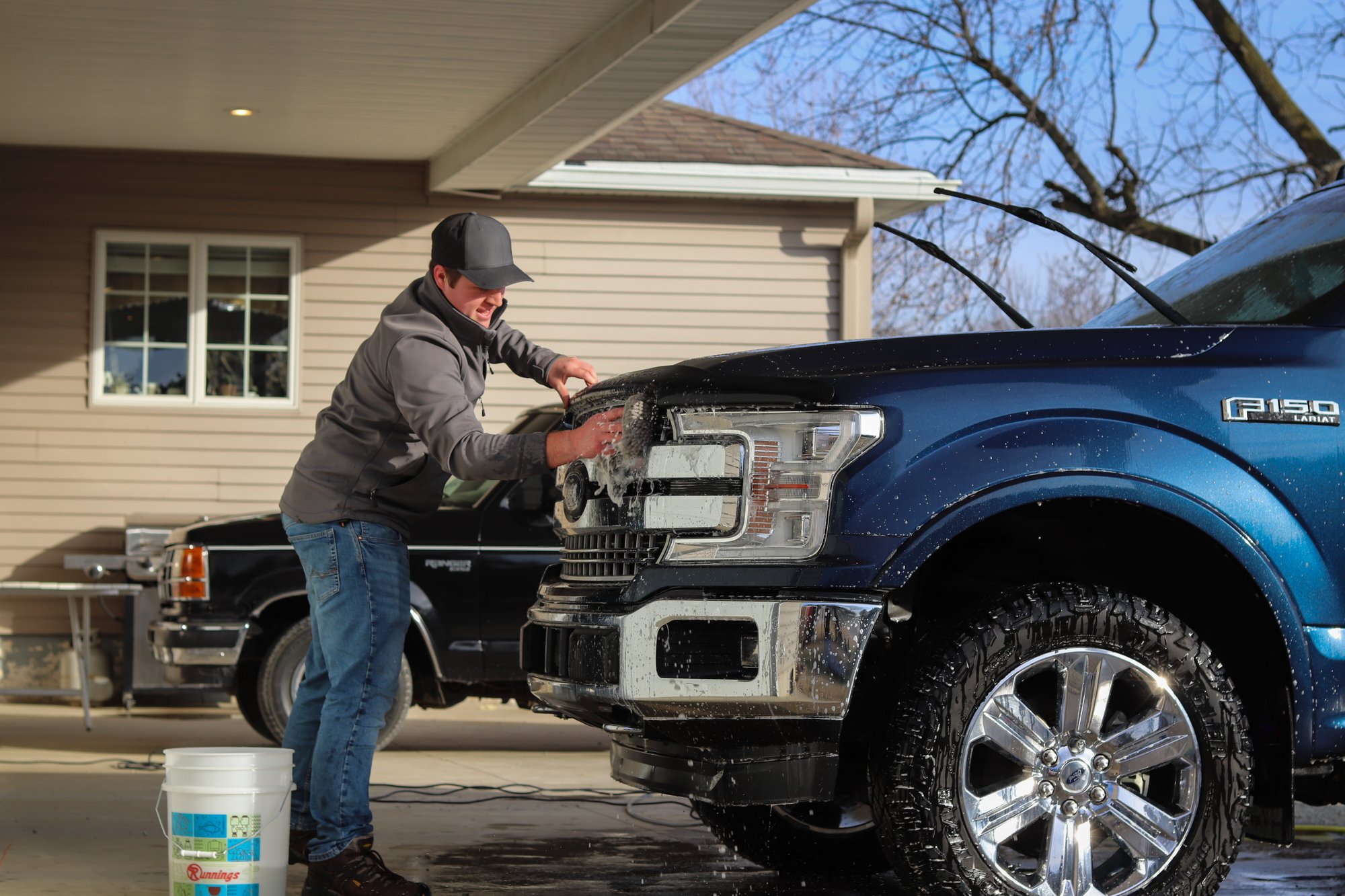 Man cleaning truck exterior.